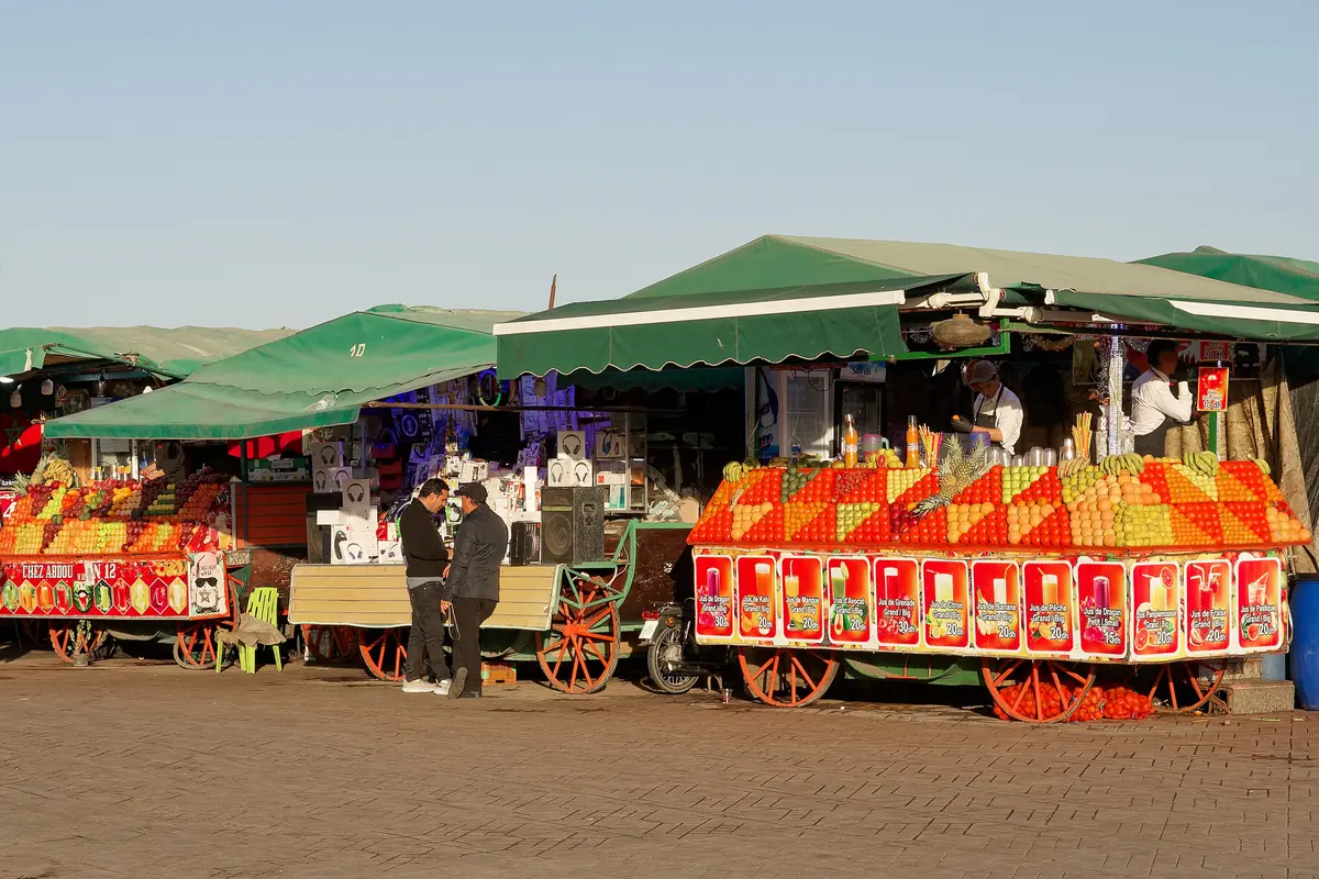 Orange juice stalls with green awnings in Jemaa el-Fna square