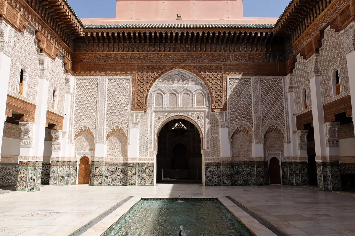 Main courtyard of the Ben Youssef Madrasa, with its pool and carved plaster and wood walls