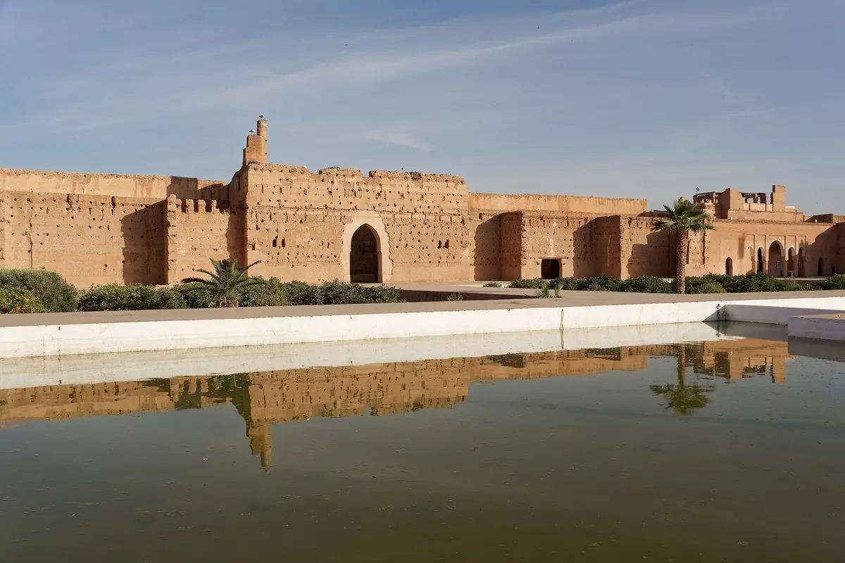 Earthen walls of El Badi Palace reflected in a long pool