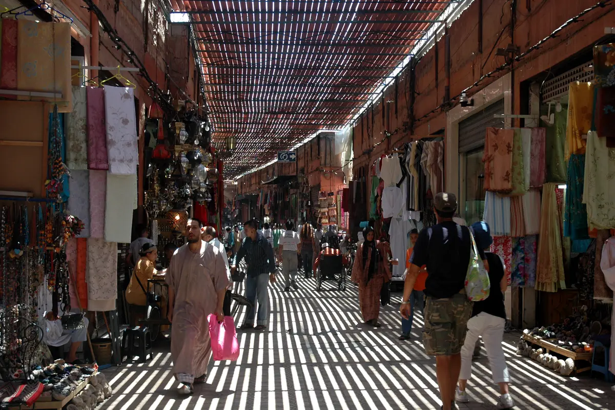 Covered street in Souk Semmarine with textile shops and people walking